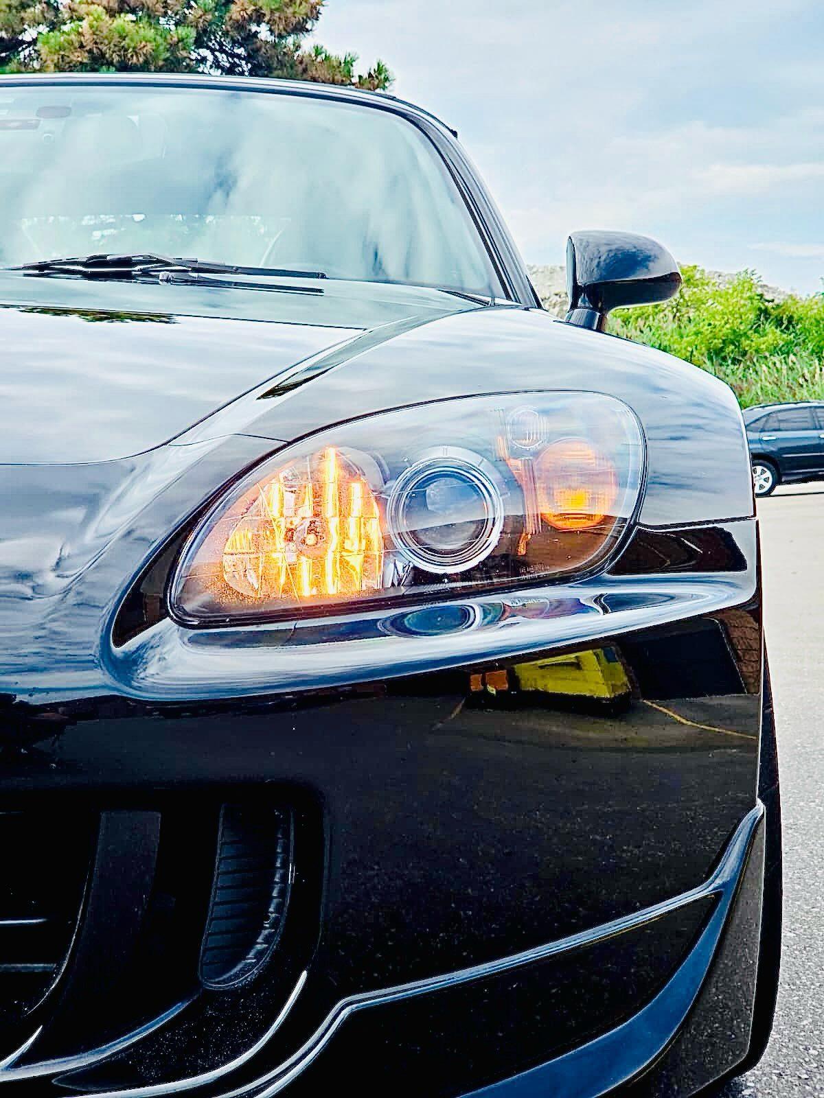 Close-up of the S2000 headlight and glossy black front bumper