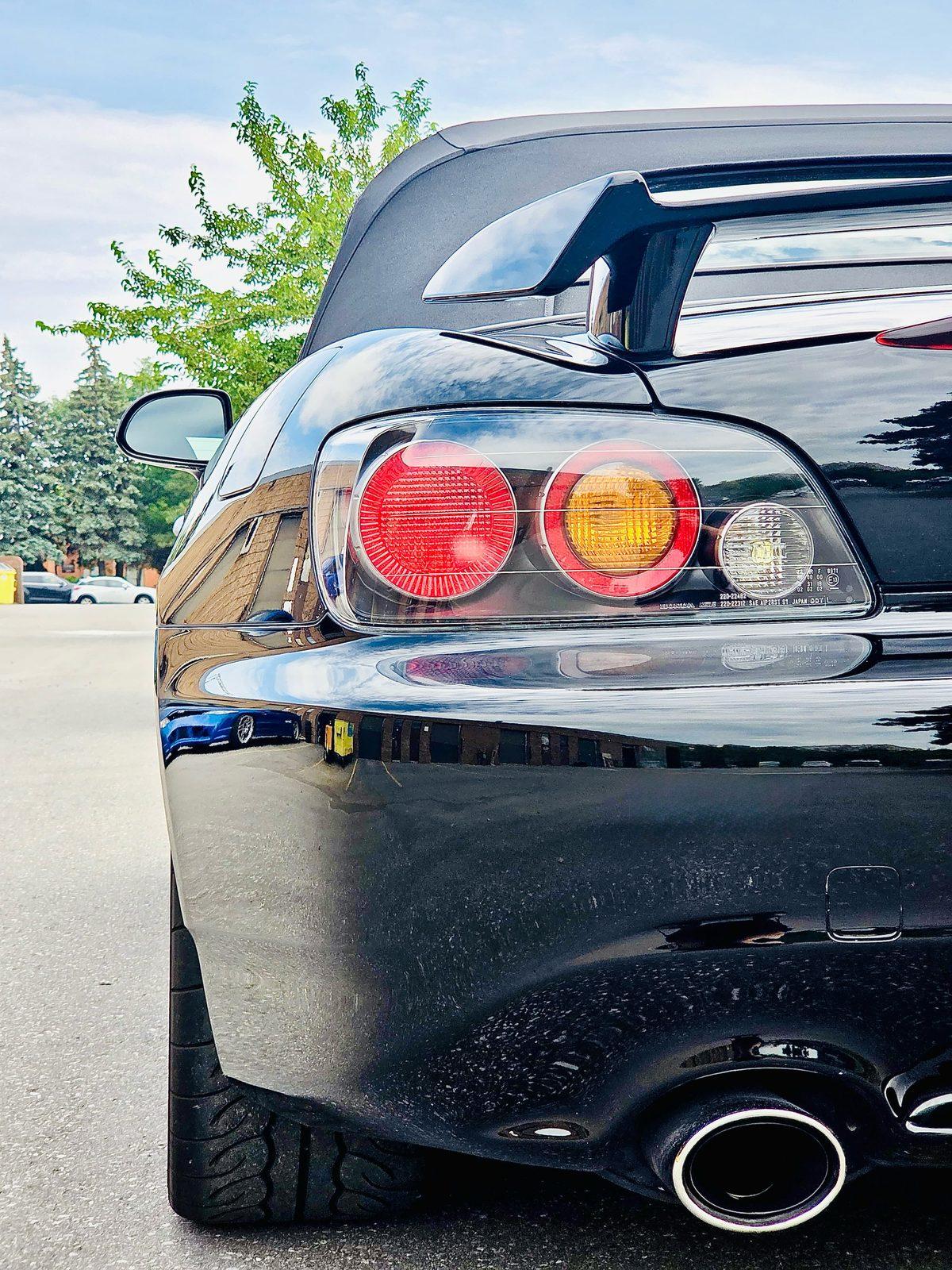 Rear of the black S2000 with glossy paint around the tail light